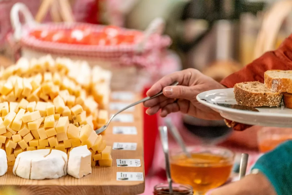 Someone scoops food from a plate onto their plate.