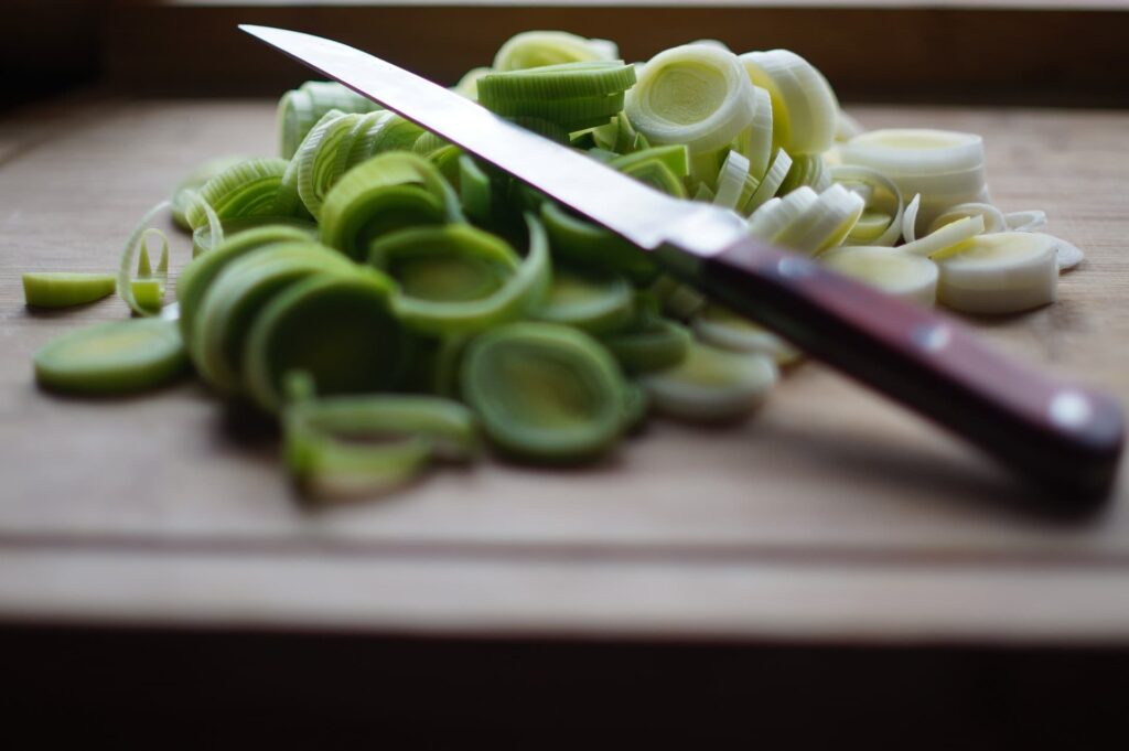 Sliced leeks with a knife on top.
