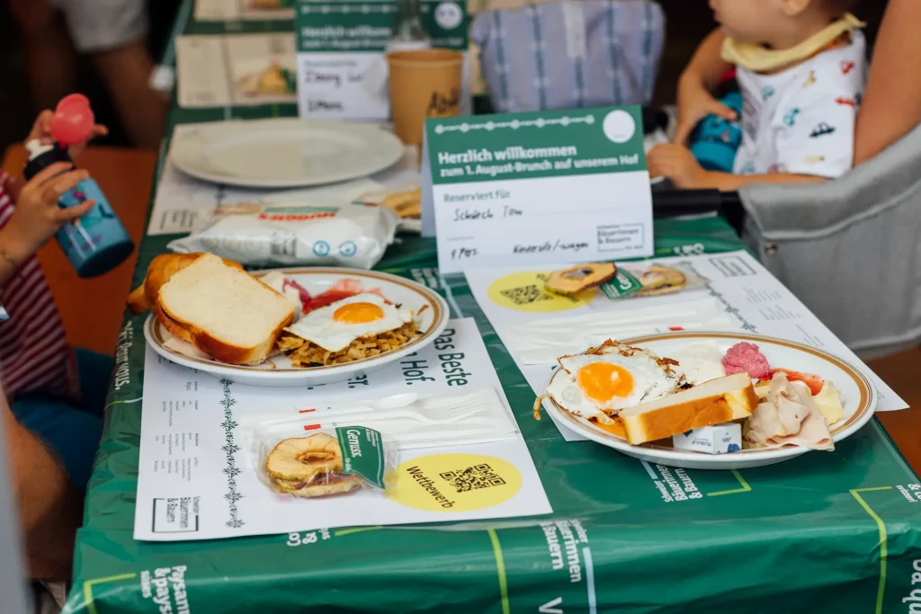 Set table with a breakfast plate, egg, and bread on a green tablecloth.
